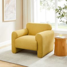 a yellow chair sitting on top of a rug in a living room next to a window