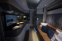 the interior of an airplane with couches and televisions on it's wall