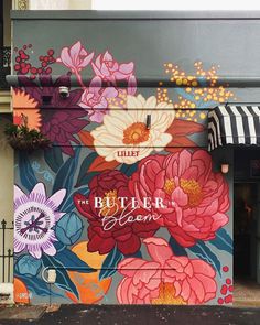 a large mural on the side of a building with flowers painted on it's sides