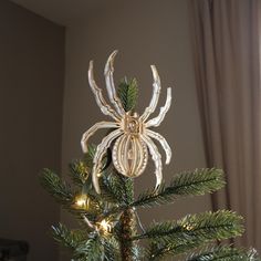 a spider ornament hanging from the top of a christmas tree