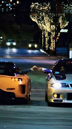 two cars parked next to each other at night