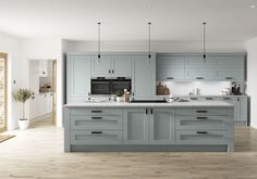 A pale blue kitchen with a shaker design, a kitchen island and matt black handle Symphony Kitchen, Black Kitchen Handles, Grey Blue Kitchen, Light Blue Kitchens, Kitchen Finishes, Blue Kitchen Cabinets, Blue Cabinets, Black Handles, Blue Kitchen