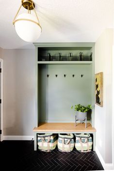 a room with some shoes on the floor and a coat rack in the corner next to it