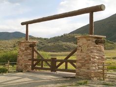 a wooden gate in the middle of an open field