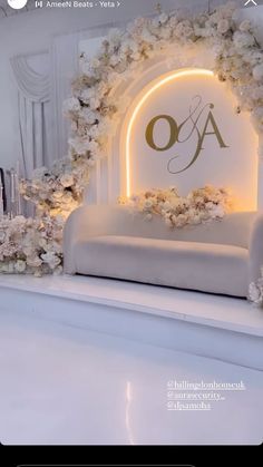 a white couch with flowers on the back and an illuminated sign that says oa