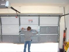 a man is standing in front of a garage door