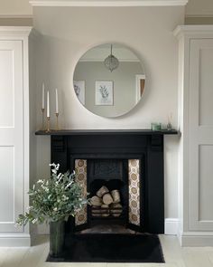 a living room with a fire place and a mirror on the wall above it's mantle