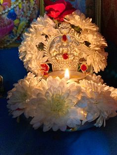 a lit candle is surrounded by flowers on a table