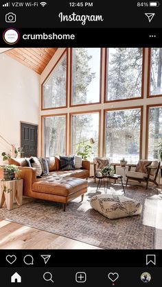 a living room filled with furniture and large windows