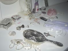 a table topped with lots of different types of jewelry next to a hair dryer