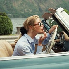 a woman sitting in the driver's seat of a car