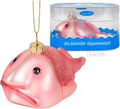 a pink fish ornament next to a box