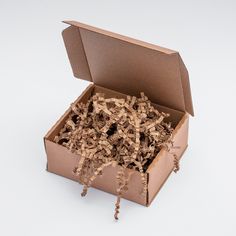 an open cardboard box filled with wood shavings