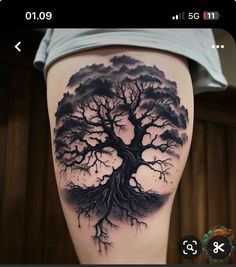 a black and white tree tattoo on the side of a woman's leg, with dark