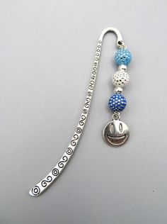 a silver and blue beaded lanyard with a smiley face charm hanging from it's side