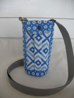 a blue and white bag sitting on top of a white table next to a gray strap