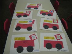 a long table topped with lots of paper cut out of firetrucks and trucks