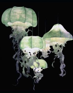 some very pretty lights that are hanging in the dark room with jellyfish on them