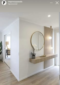 a white room with a mirror, sink and table in the corner on the wall