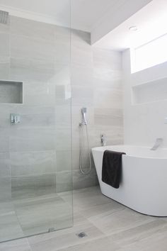 a white bathtub sitting next to a walk in shower