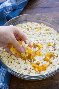 a person is scooping pumpkin seeds into a bowl