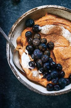 a pancake with blueberries and powdered sugar on top is in a bowl