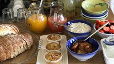 the table is full of breakfast foods including muffins, strawberries and orange juice