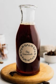 a bottle filled with liquid sitting on top of a wooden board