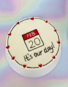 a white cake with red hearts on it that says, feb 20th its our day