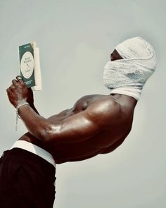 a man with a towel on his head holding up a book