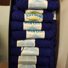 several rolls of blue yarn are stacked on top of each other in a metal container