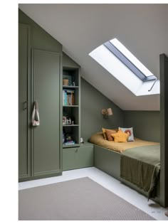 a bed sitting under a skylight in a bedroom next to a book shelf and cupboards