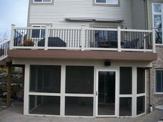 a large white house with two balconies on the second floor and an attached deck