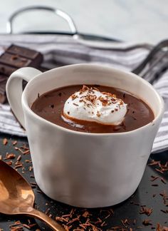 a cup of hot chocolate with whipped cream and chocolate shavings on the side