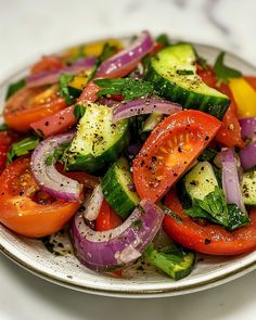 a white plate topped with lots of veggies on top of a marble counter