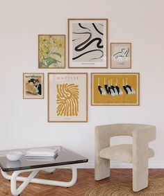 a living room with pictures on the wall and a glass table in front of it