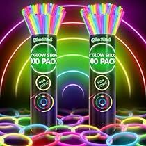 two spray cans filled with neon colored straws on top of a circular table covered in circles