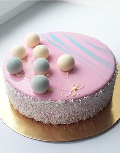 a pink cake with white and blue decorations