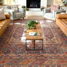 a living room with couches, chairs and a rug on the floor in front of a fireplace