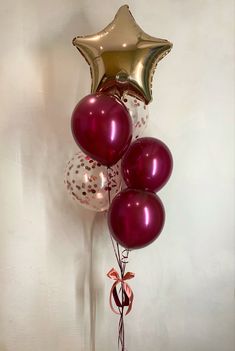 some balloons are tied to a pole with a star balloon attached to the top one