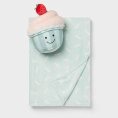 a blue towel with a strawberry on top and a cupcake in the middle that has been made to look like an ice cream cone