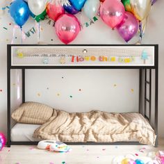 a bunk bed with balloons and confetti on the wall