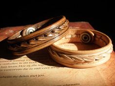 two wooden bracelets sitting on top of an open book