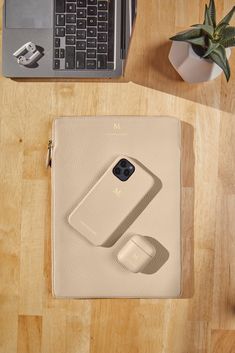 an overhead view of a laptop, cell phone and other items on a wooden table