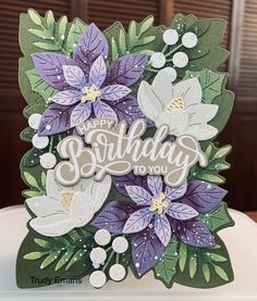 a birthday card with purple flowers and green leaves