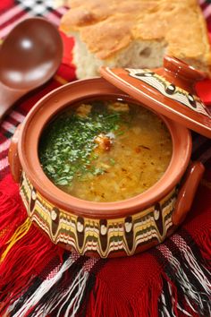 a bowl of soup on a table with bread