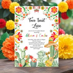 a mexican themed wedding card with flowers and cacti in the background on a wooden table