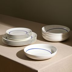 a table topped with white plates and bowls