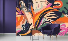 a purple chair sitting in front of a colorful wall mural