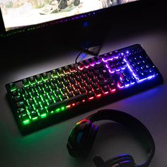 a computer keyboard and headphones on a desk